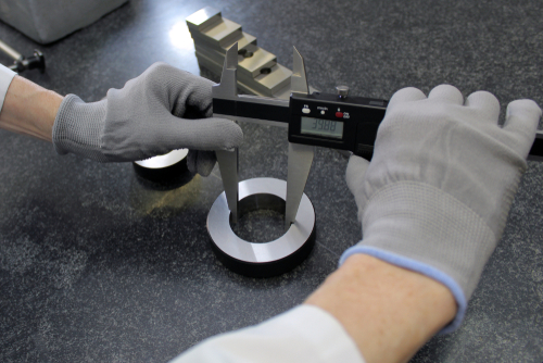 Calibers being used to measure the inner diameter of a part.
