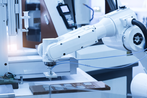 Robotic arm at production line in factory.