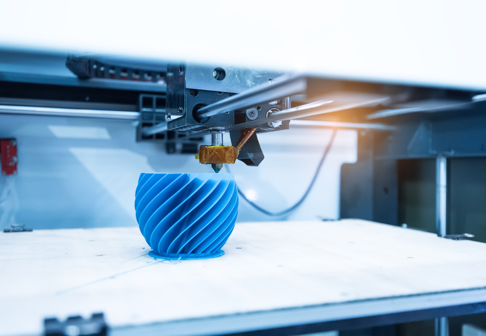 3D printer manufacturing a spiraling blue object.
