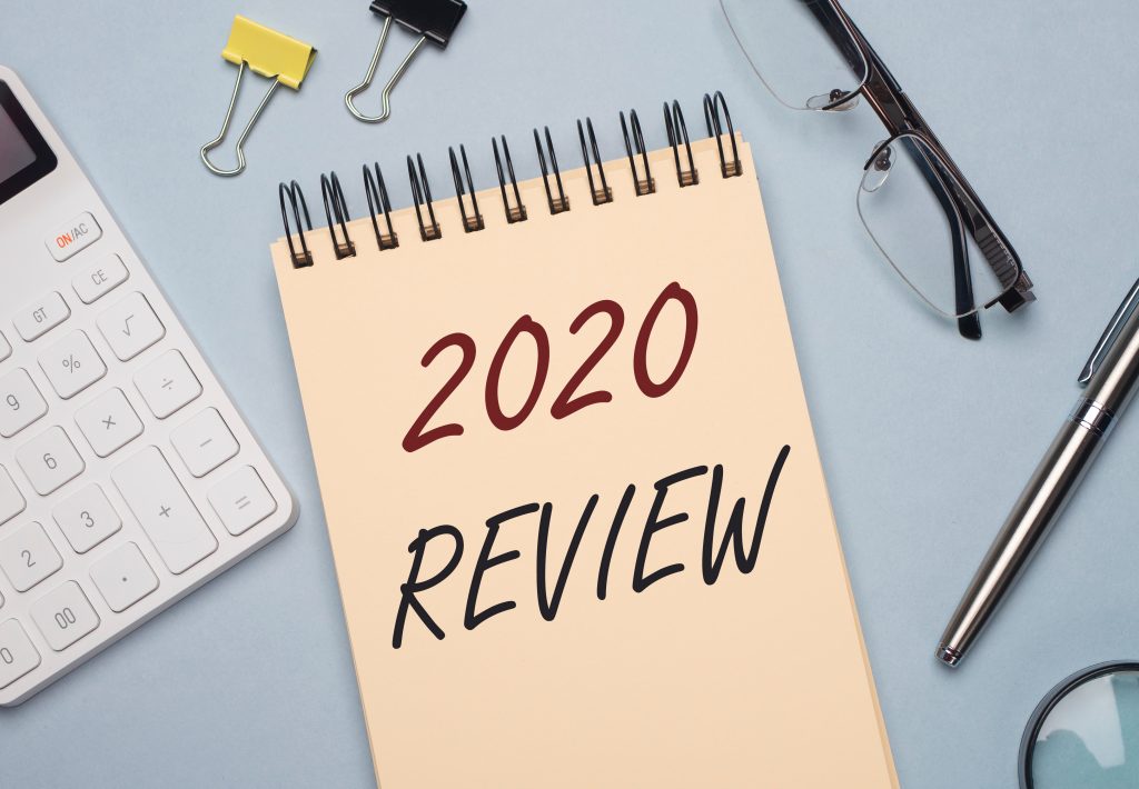 2020 review, written on a notepad and surrounded by office supplies.