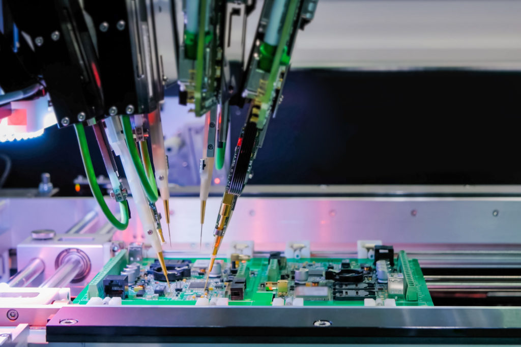 Automated semiconductor manufacturing, robotic arms assembling a circuit board.
