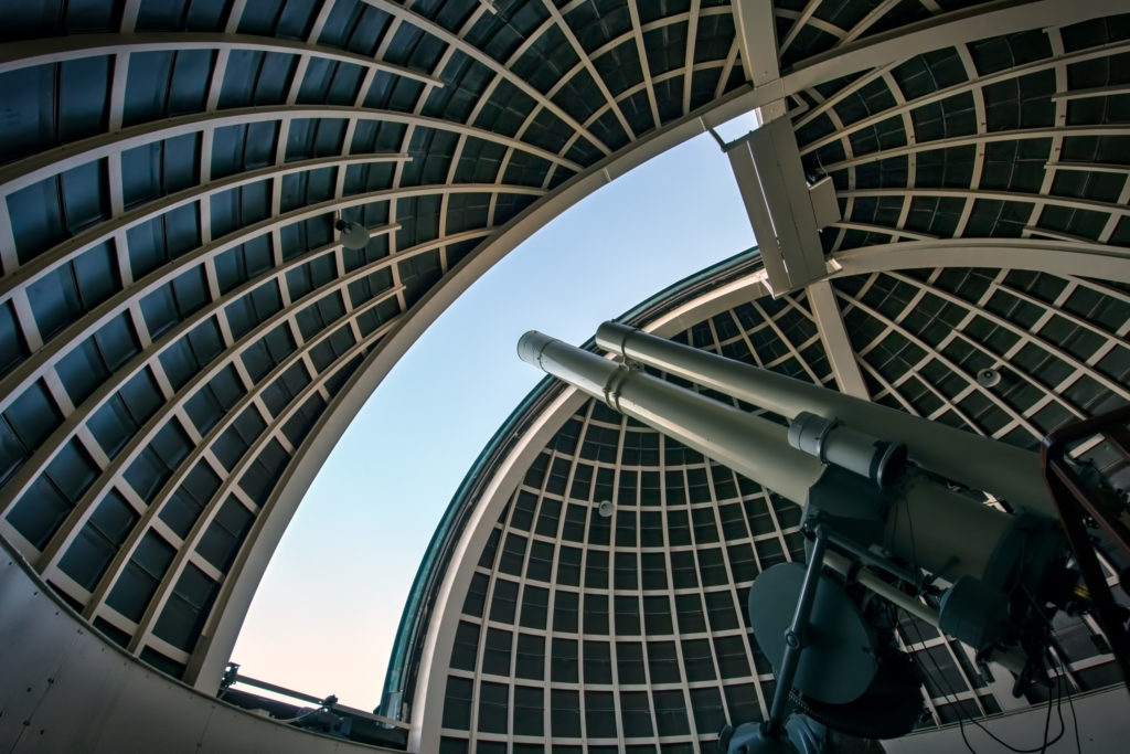 Observatory telescope pointing through open roof.
