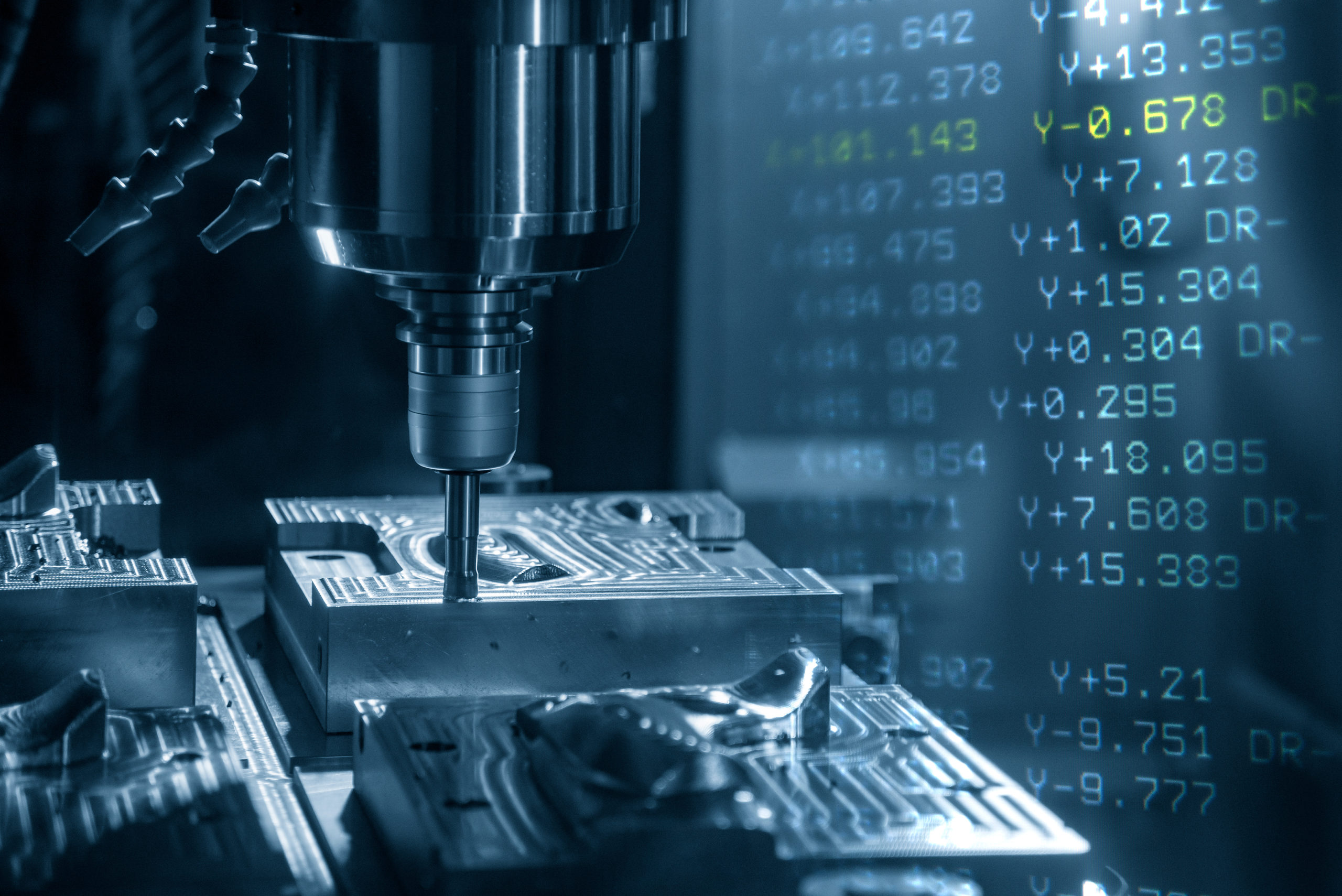 CNC machining process with G code in the background
