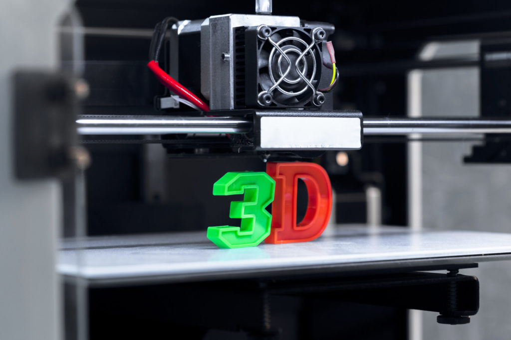 Image of the word 3D being printed, with the “3e” in green and the “D” in red.