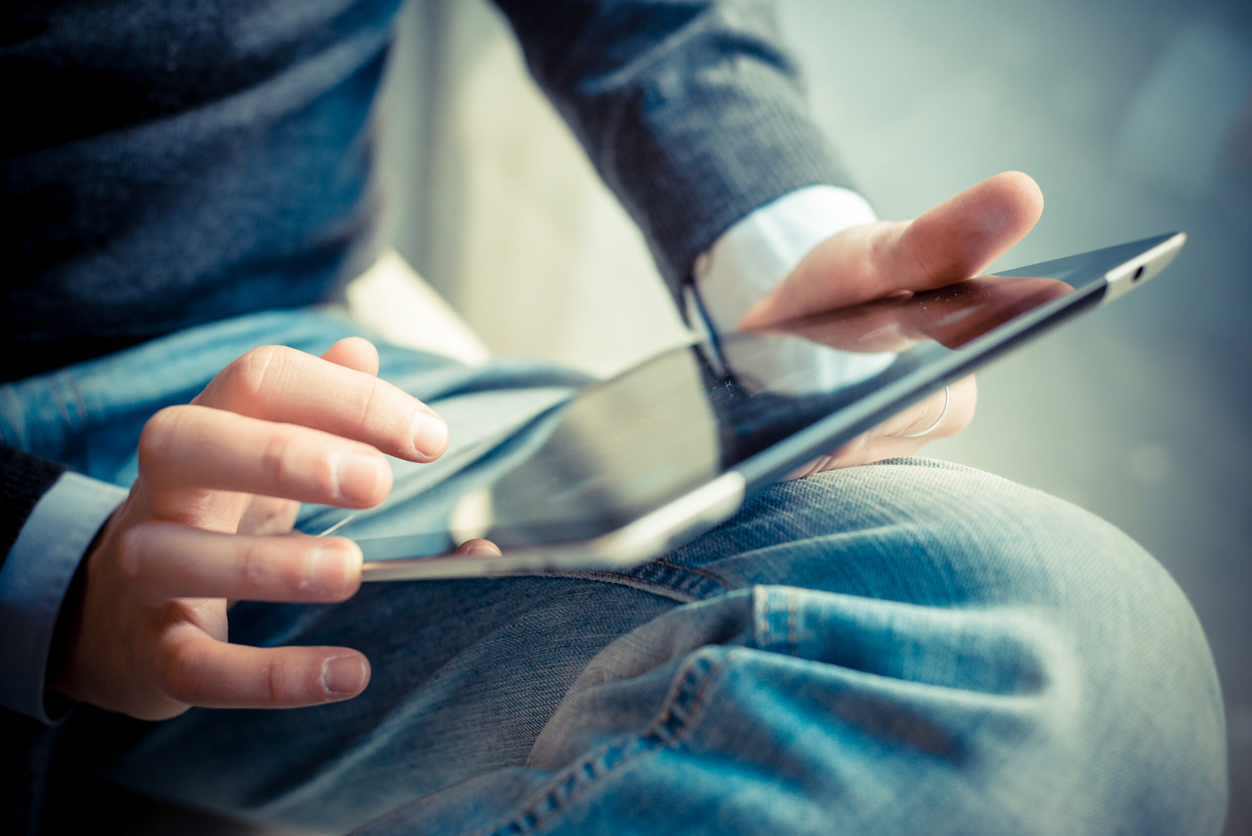 Person using a tablet computer in their lap