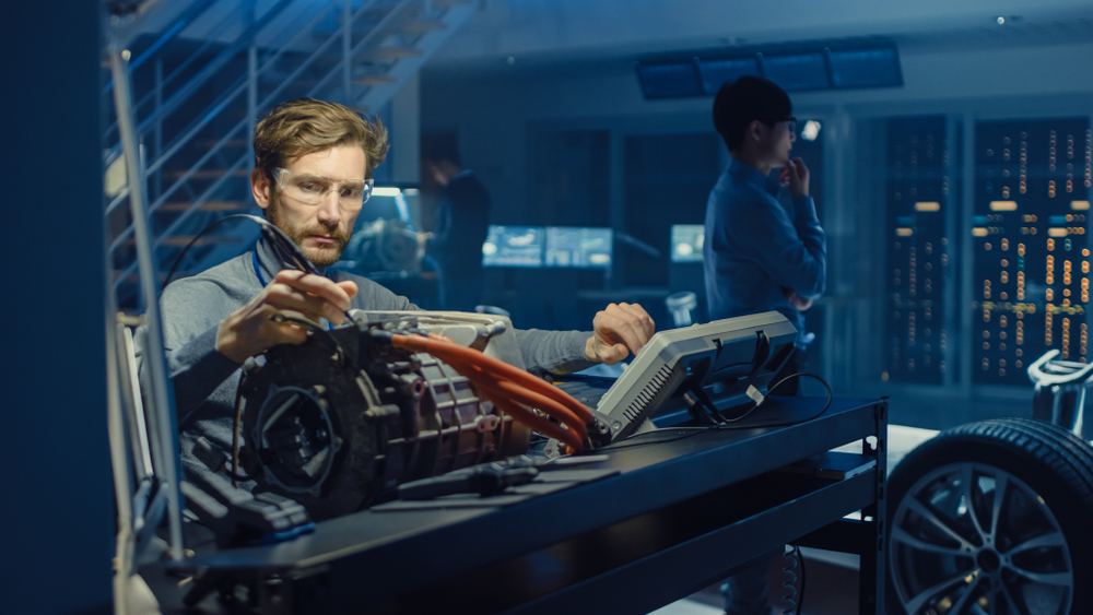 Technician with EV motor performing tests in a laboratory