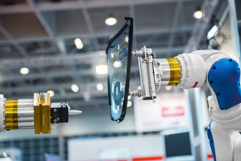 Robotic arm placing car window into chassis in manufacturing plant